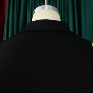 Detail of elegant black blazer collar and shoulder tailoring on a sleek jumpsuit