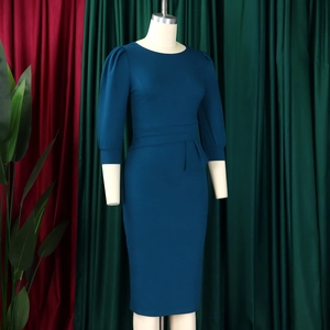Close-up of teal slim-fit dress with puff sleeves and asymmetric peplum waist detail