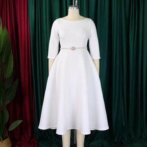 Detail of white round neck midi dress with pearl rhinestone belt and flared skirt