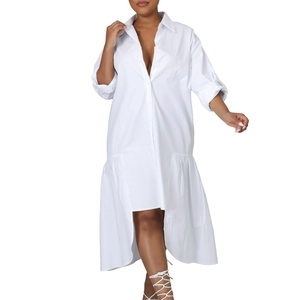 Detail of white cotton shirt dress featuring an irregular ruffled high-low hemline