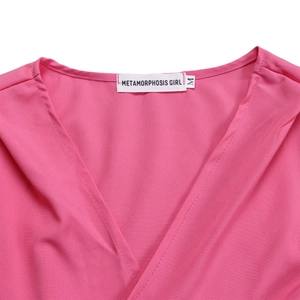Détail du haut rose à col en V montrant l'étiquette METAMORPHOSIS GIRL et taille M