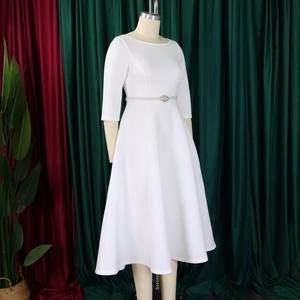 Detail of white A-line evening dress with decorative pearl belt and 3/4 sleeves