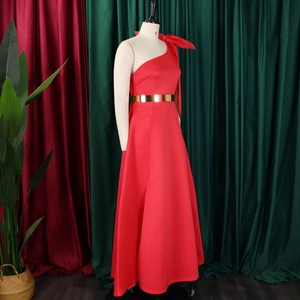 Detail of red one-shoulder evening gown with a large bow and metallic gold belt