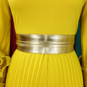 Gros plan sur la combinaison plissée jaune vif avec une large ceinture dorée