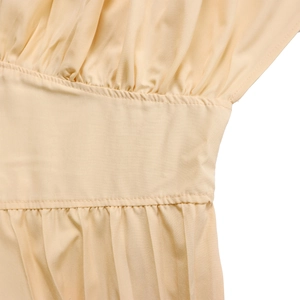 Détail de la taille haute plissée et des coutures sur une combinaison jaune