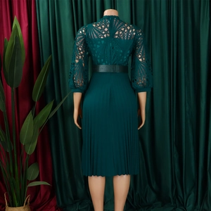 Detail of dark green lace bodice and pleated skirt with a black waist belt on mannequin