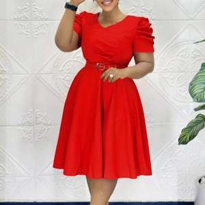 Détail d'une robe rouge élégante à col en V avec manches bouffantes et ceinture assortie