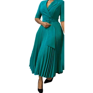 Détail de la robe plissée vert foncé avec col en V à revers et ceinture assortie incluse