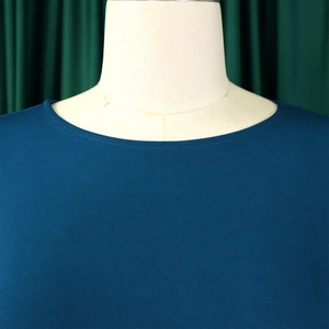 Detail of the round neckline and smooth knit fabric on a navy blue dress