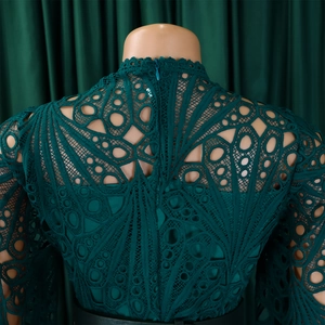 Detail of dark green lace dress with geometric cutouts and invisible back zipper