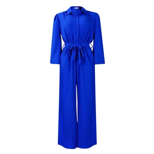 Detailed view of royal blue long sleeve jumpsuit with waist tie and button-up lapels