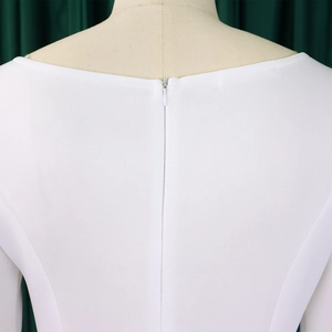 Detailed close-up of invisible back zipper and vertical ribbed texture on white dress