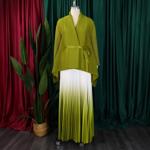 Dettaglio del top a pieghe verde oliva e gonna lunga con sfumatura di colore bianco-verde
