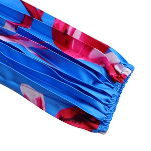 Dettaglio della manica in chiffon floreale blu e rosa con pieghe a punto smock e polsini elastici