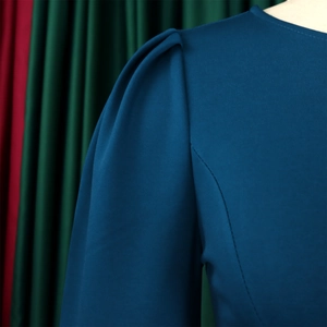 Detail of puffed sleeves and fine fabric texture on a navy blue round-neck dress