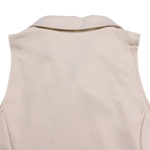Detailed macro view of the lapel collar and fine stitching on a beige wide-leg jumpsuit