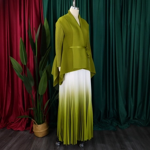 Dettaglio di top a pieghe verde e gonna maxi sfumata con design a fiocco elegante