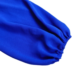 Detail of royal blue long sleeve jumpsuit showing elastic cuffs and fabric texture