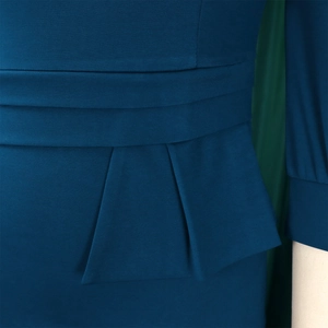 Close-up of pleated waist detail and fabric texture on peacock blue pencil dress