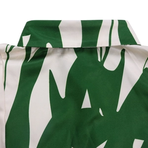Détail rapproché d'un col classique sur une chemise à imprimé tropical vert et blanc