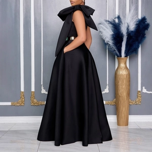 Detail of elegant black one-shoulder evening gown featuring a large bow and gold belt detail