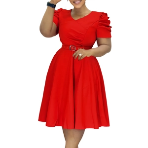 Détail d'une robe rouge à col en V avec manches bouffantes et ceinture à boucle métallique