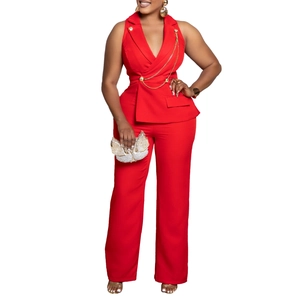 Detail view of the red tailored suit collar and decorative gold chains on the jumpsuit