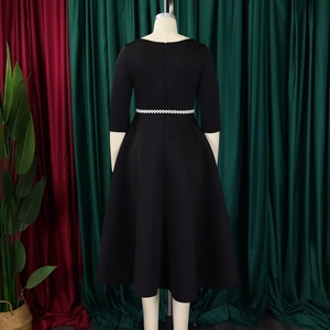 Detail of elegant black A-line dress with three-quarter sleeves and pearl waist belt