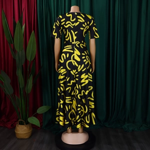 Detailed back view of a long dress with yellow abstract graffiti patterns on black fabric