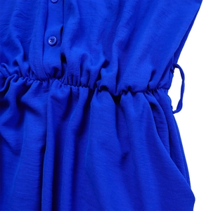 Detail view of royal blue jumpsuit with elastic waist, buttons and side pockets
