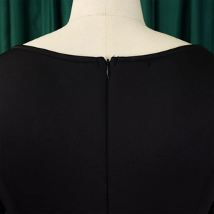 Detail view of invisible zipper and fine texture on the back of a black evening dress