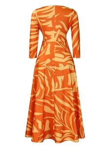 Detail view of the back of a vibrant orange tropical print midi dress with leaf pattern