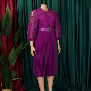 Close-up of intricate lace embroidery and metal buckle belt on a magenta pleated dress