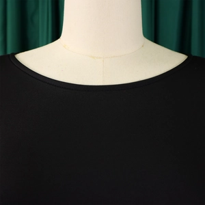 Detailed close-up of the round neckline and sewing craftsmanship on the black evening dress