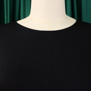 Close-up of the fine double-needle stitching on the round neckline of a black knitted top