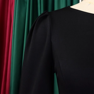 Close-up of elegant puff shoulder and textured fabric on a black long sleeve dress