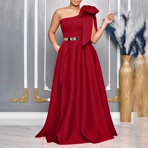 Detail of red one-shoulder gown featuring large bow and gold mirrored waist belt