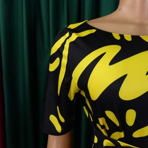 Detail of boat neck and yellow abstract wave print on black short sleeve dress