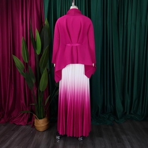 Dettaglio del cardigan fucsia con fiocco posteriore e gonna a pieghe sfumata elegante