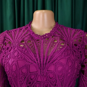 Close-up of plum purple lace dress featuring intricate hollow geometric patterns and scalloped neck