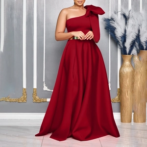 Detail of burgundy satin dress with off-shoulder bow and golden metallic waist belt