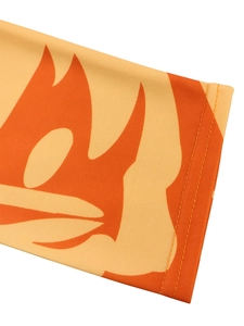 Detail of light orange knit fabric with flame print and professional double-needle stitching