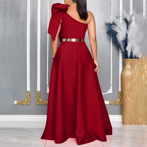 Rear view of a burgundy one-shoulder gown with an oversized bow and gold metallic belt