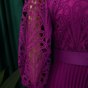 Detailed view of purple lace hollow-out design and fine pleated texture on a long dress