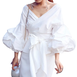 Detail of white wrap V-neck blouse with tiered puff sleeves and large bow waist tie