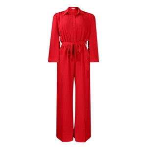 Detail of red long sleeve jumpsuit showing lapel collar, button front, and tie-waist belt