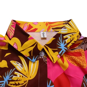 Détail de l'imprimé floral tropical sur une chemise à revers avec étiquette de taille M