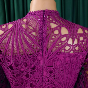 Detail of purple lace dress featuring hollow-out floral patterns and back zipper
