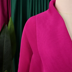 Dettaglio della texture a pieghe rosa fucsia su un elegante top con maniche a pipistrello