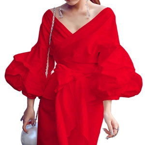 Detail of red V-neck blouse featuring dramatic puff sleeves and a large waist bow tie knot